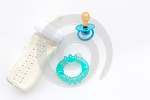 Preparation of mixture baby feeding with infant formula powdered milk in bottle with toys on white background top view