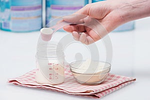 Preparation of mixture baby feeding on white table background