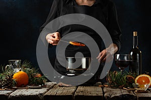 Preparation of mulled wine from wine, against the background of ingredients. Recipe and illustration of a book of recipes,