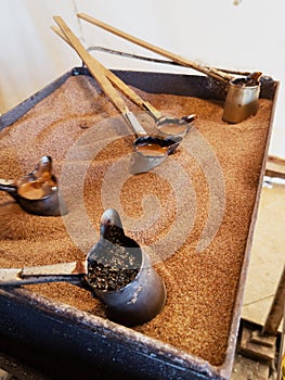 Preparation of natural coffee in Turks on the sand.