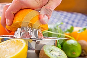 Preparation of orange grape or multivitamin juice, hands squeeze