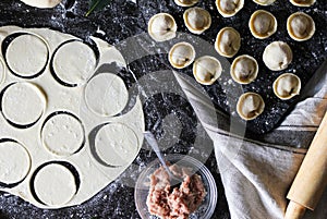 Preparation of pelmeni. Top view. Ingredients on black table. Traditional Russian cuisine.