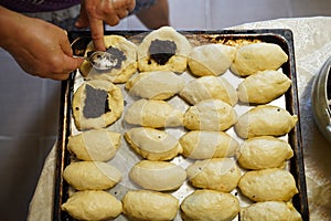 Preparation of pies with poppy seeds. The hands of the cook prepare the cake