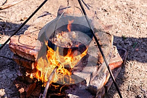 Preparation of raditional armenian pilaf in a cauldron on an open fire