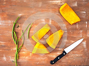 Preparation for roasting pumpkin. Sliced pumpkin, kitchen knife and celery stalks