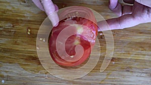 Preparation of a salad of red ripe tomatoes of medium size on the background of