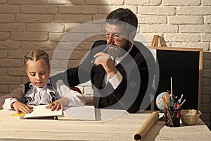 Preparation for school. Schoolgirl and her tutor with serious faces write in notebook