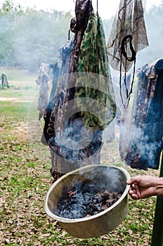 Preparation to hunt by smoking hunting clothes to mask human scent.