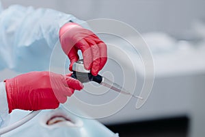 Preparation of tools for brushing teeth by a dentist in the dental office. Hands with tool close up