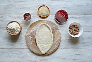 Preparation of traditional Arabic pizza manaqish with meat.