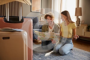Preparation for vacation concept with happy spouses searching travel rout in map photo