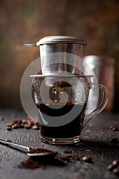 Preparation of Vietnamese coffee with aluminum filer on dark background