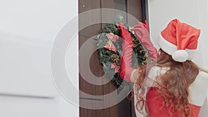 Preparation for the winter New Year holidays. A woman in red decorates her house with Christmas decor. Waiting for the