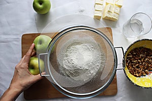 Preparations for Apple pie: flour, apples, butter, nuts. Homemade cake