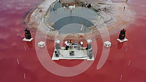 Preparations for a massive beach party on the shore of a pink lake, aerial shot