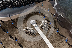 Preparations of wedding party on small beach next to sea