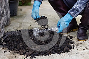 Prepare black soil in used plastic containers. for planting Conserving natural resources and the environment sustainable world