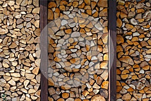 They prepare firewood for heating in winter. Firewood is neatly stacked under the roof of the shed for heating.