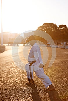 Prepare to fight. A young karate professional practicing while wearing a gi.