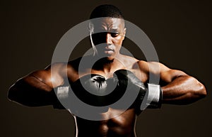 Prepare to meet your fate. Studio shot of a handsome young man boxing against a black background.
