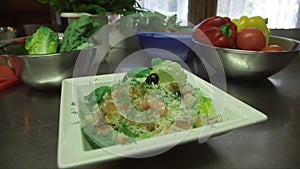 prepared caesar salad with shrimp in kitchen, camera dolly in