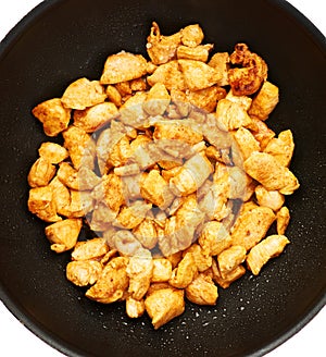 Prepared chicken fillet cutted into pieces and spiced in pan isolated over white background