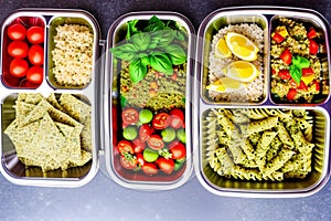 Prepared diet Lunches in lunch boxes: pasta, parmesan, lettuce, cherry tomatoes with basil.