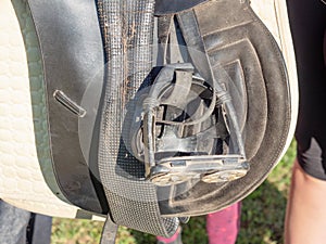 Prepared english saddle with stirrups. Dressage of horses club.