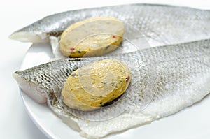 Prepared for fry boneless sea bass fillets with a lemon and pepper butter