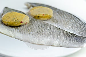 Prepared for fry boneless sea bass fillets with a lemon and pepper butter