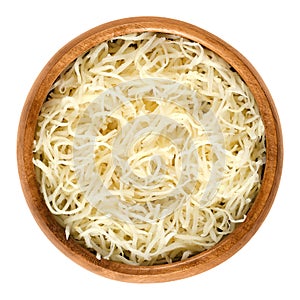 Prepared horseradish in wooden bowl over white