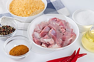 Prepared ingredients for cooking pilaf in modern multi cooker in kitchen on a table. Cooking pilau with meat in multicooker