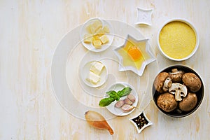 Prepared ingredients for cooking polenta with fried mushrooms and an egg on a light concrete background. Step by step recipes.