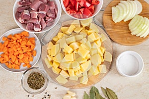 Prepared ingredients for cooking stewed potatoes with meat in multi cooker in kitchen on a table. Cooking stewed potatoe with meat