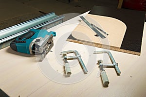 Prepared tool jigsaw with wood clamps and a pencil with a ruler lying