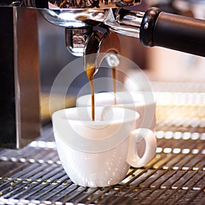 Prepares espresso in his coffee shop; close-up