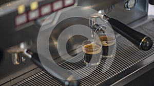 Prepares espresso in his coffee shop; close-up.