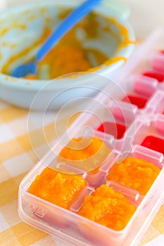 Preparing baby food, homemade. Healthy boiled or steamed crinkle sliced fresh carrots  preparing to be made as an ice cube in ice