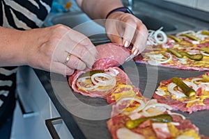 Preparing beef rouladen, fresh raw meat coated with mustard and onions