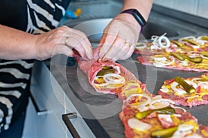 Preparing beef rouladen, fresh raw meat coated with mustard and onions