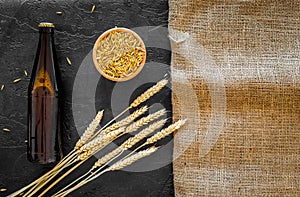 Preparing beer. Barley near beer bottle and glass on black and canvas background top view mockup