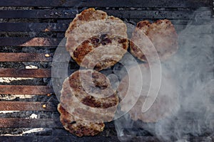 Preparing burger patties on a grill outdoors