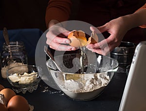 Preparing a cake recipe. We look at the recipe in the tablet. Break the eggs into a bowl. Pouring out the egg. In the background