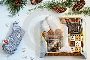 Preparing care package, seasonal gift box with coffee, chocolate, warm socks, walnuts. Personalized handmade gift box for