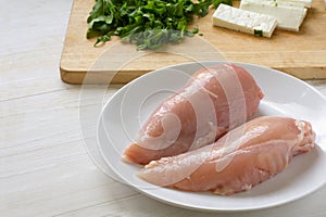 Preparing chicken breast fillet, lean poultry meat, feta cheese