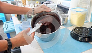 Preparing chocolate sauce in pot, liquid chocolate in a pot and stir with white spatula