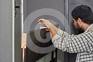 Preparing the door for installation. The master installs a door lock