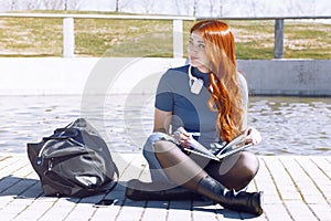 Preparing for exams outdoors. young student looking to the side pensively with a notepad while sitting in a park.