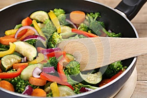 Preparing food vegetables in cooking pan with spatula