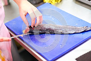 Preparing a fresh fish by gutting and filleting, chef filleting fish at the kitchen